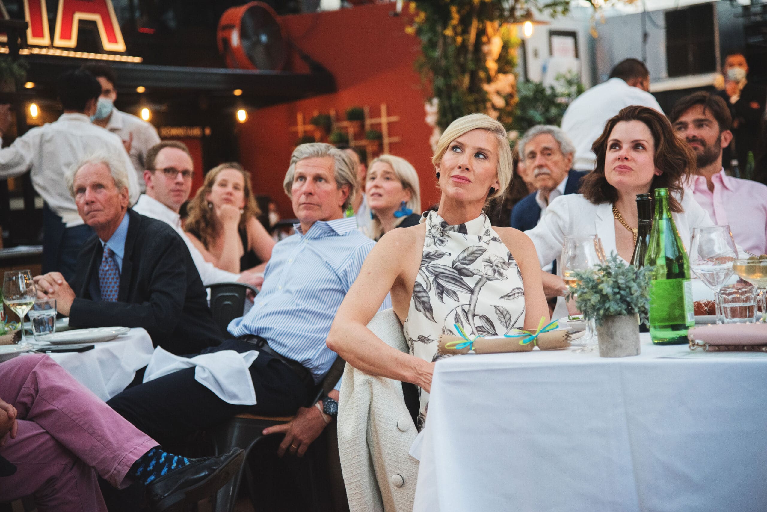 Guests at the GO Project Spring Benefit seated at tables look on as programming commences.