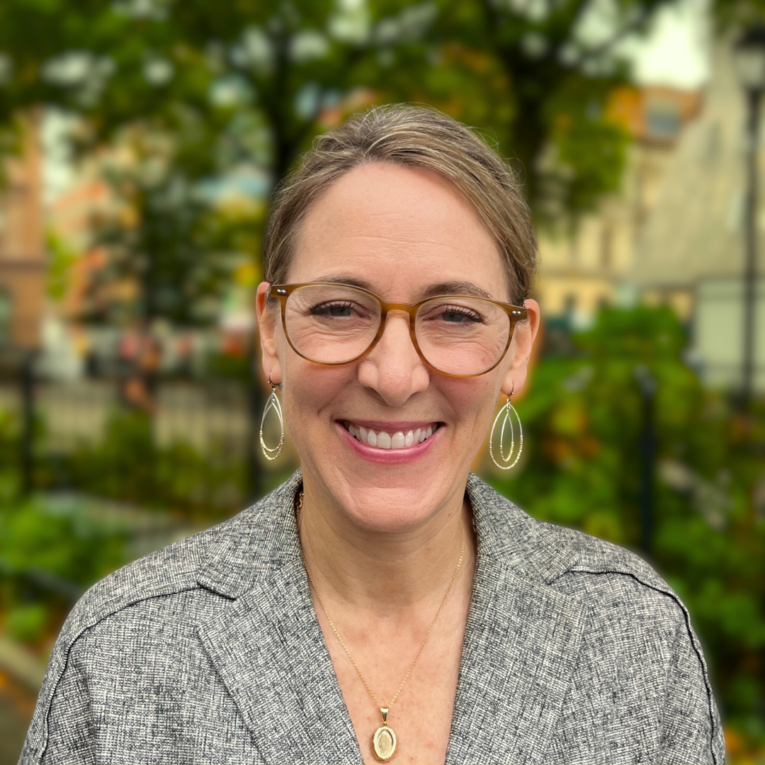 Gayle Villani smiles in a lush green park.