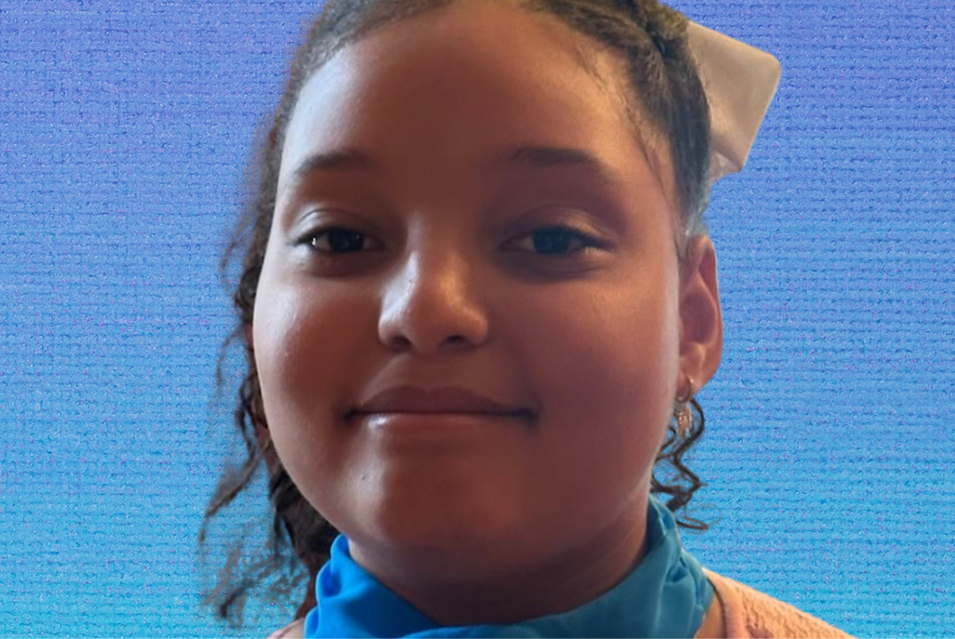 Chrissa smiles in front of a blue background.