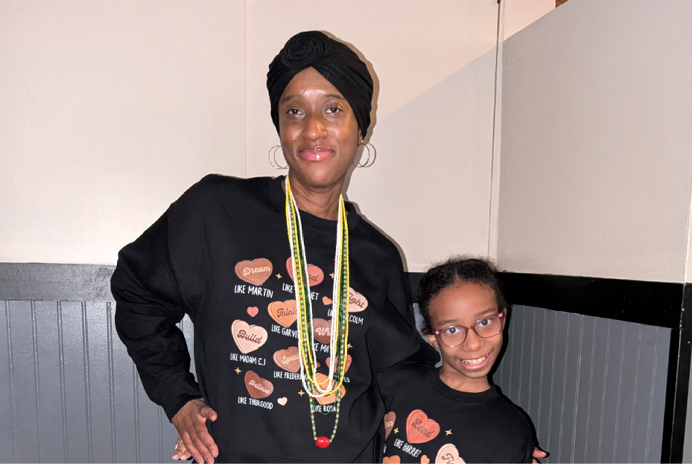Olivia and her mother Laverne smile in matching black sweatshirts with an arm around each other.